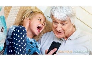 Grandad & Grandaughter listening to phone with earphones